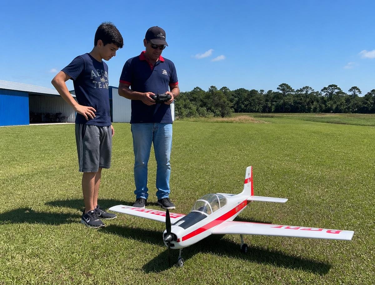 Instrutor orientando aluno em aula de aeromodelismo